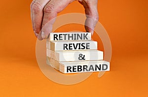 Rethink revise rebrand symbol. Concept word Rethink Revise and Rebrand on beautiful block. Beautiful orange background. Business