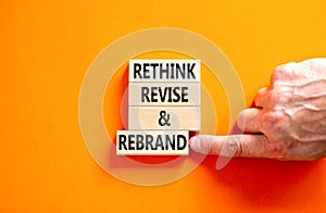 Rethink revise rebrand symbol. Concept word Rethink Revise and Rebrand on beautiful block. Beautiful orange background. Business