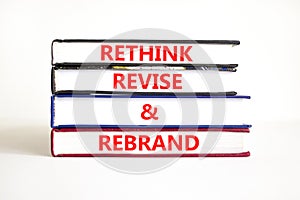 Rethink revise rebrand symbol. Concept word Rethink Revise and Rebrand on beautiful book. Beautiful white table white background.