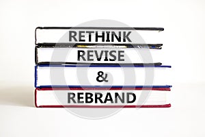 Rethink revise rebrand symbol. Concept word Rethink Revise and Rebrand on beautiful book. Beautiful white table white background.