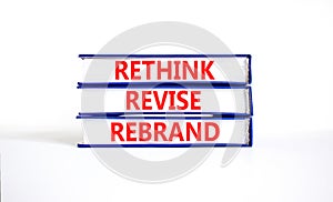 Rethink revise rebrand symbol. Concept word Rethink Revise Rebrand on beautiful books. Beautiful white table white background.