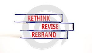Rethink revise rebrand symbol. Concept word Rethink Revise Rebrand on beautiful books. Beautiful white table white background.