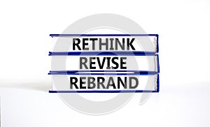 Rethink revise rebrand symbol. Concept word Rethink Revise Rebrand on beautiful books. Beautiful white table white background.