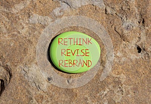 Rethink revise rebrand symbol. Concept word Rethink Revise Rebrand on beautiful green stone. Beautiful brown stone background.