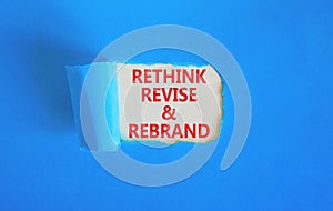 Rethink revise rebrand symbol. Concept word Rethink Revise and Rebrand on beautiful white paper. Beautiful blue paper background.