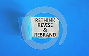 Rethink revise rebrand symbol. Concept word Rethink Revise and Rebrand on beautiful white paper. Beautiful blue paper background.