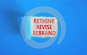 Rethink revise rebrand symbol. Concept word Rethink Revise Rebrand on beautiful white paper. Beautiful blue table background.