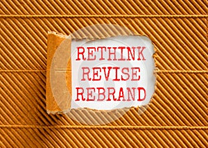 Rethink revise rebrand symbol. Concept word Rethink Revise Rebrand on beautiful white paper. Beautiful brown table background.