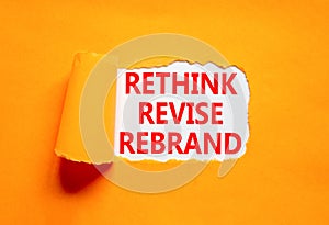 Rethink revise rebrand symbol. Concept word Rethink Revise Rebrand on beautiful white paper. Beautiful orange table background.