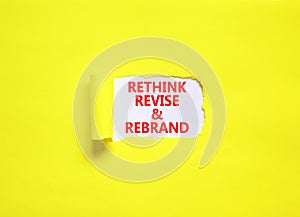 Rethink revise rebrand symbol. Concept word Rethink Revise and Rebrand on beautiful white paper. Beautiful yellow background.