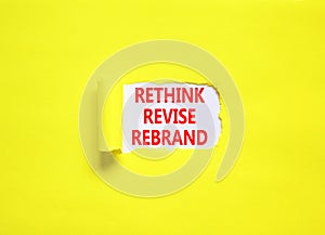 Rethink revise rebrand symbol. Concept word Rethink Revise Rebrand on beautiful white paper. Beautiful yellow table background.