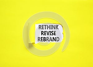 Rethink revise rebrand symbol. Concept word Rethink Revise Rebrand on beautiful white paper. Beautiful yellow table background.