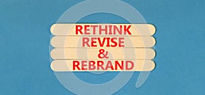 Rethink revise rebrand symbol. Concept word Rethink Revise and Rebrand on beautiful wooden stick. Beautiful blue background.