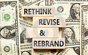 Rethink revise rebrand symbol. Concept word Rethink Revise and Rebrand on block. Dollar bills. Beautiful background from dollar