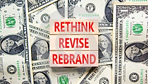 Rethink revise rebrand symbol. Concept word Rethink Revise Rebrand on block. Dollar bills. Beautiful dollar bills background.