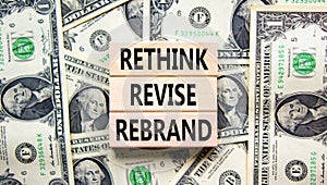 Rethink revise rebrand symbol. Concept word Rethink Revise Rebrand on block. Dollar bills. Beautiful dollar bills background.