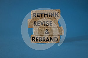 Rethink revise rebrand symbol. Concept word Rethink Revise and Rebrand on brick blocks. Beautiful blue background. Business brand