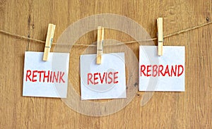 Rethink revise rebrand symbol. Concept word Rethink Revise Rebrand on white paper on clothespin. Beautiful wooden background.