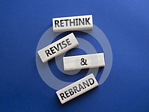 Rethink Revise and Rebrand symbol. Wooden blocks with words Rethink Revise and Rebrand. Beautiful deep blue background. Business