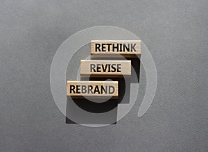 Rethink Revise Rebrand symbol. Wooden blocks with words Rethink Revise Rebrand. Beautiful grey background. Business and Rethink