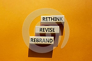 Rethink Revise Rebrand symbol. Wooden blocks with words Rethink Revise Rebrand. Beautiful orange background. Business and Rethink