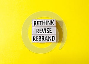 Rethink Revise Rebrand symbol. Wooden blocks with words Rethink Revise Rebrand. Beautiful yellow background. Business and Rethink