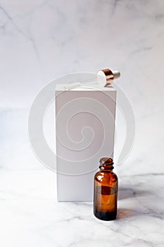 Retinol oil serum oil bottle on isolated marble background. Beauty care concept photo