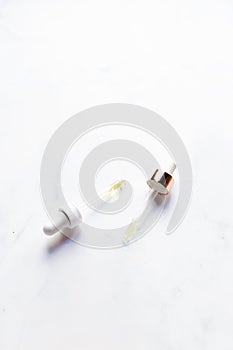 Retinol oil serum oil pipettes on isolated marble background. Beauty care concept photo