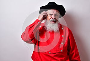 Retired American male with red western bib shirt scratching his head and frowning