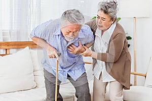 Retired Asian senior elderly husband pain from heart attack disease or illness with serious or worried wife take care at home.