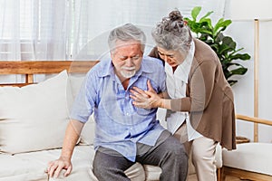 Retired Asian senior elderly husband pain from heart attack disease or illness with serious or worried wife take care at home.