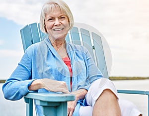 Retired but certainly not tired. Portrait of a happy senior woman relaxing on a chair outside.