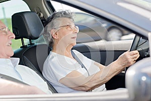 Retired couple in car woman driving