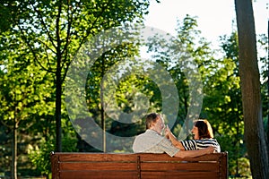 Retired couple having fun on the park bench.