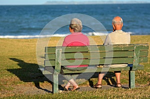 Retired couple sit on a bench
