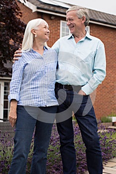 Retired Couple Standing Outside Home