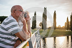 retired couple watching the sunset from a bridge