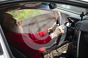 Senior  man with long beard driving gray car