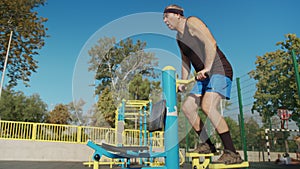 A retired elderly man works out on a sports ground outside. Healthy lifestyle concept.