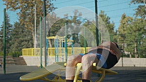 A retired elderly man works out on a sports ground outside. Healthy lifestyle concept.