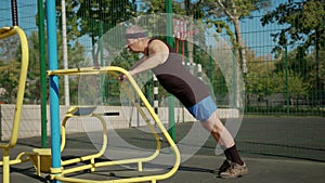 A retired elderly man works out on a sports ground outside. Healthy lifestyle concept.