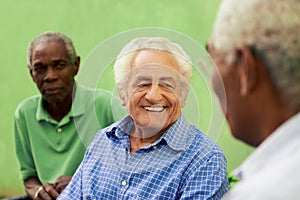 Group of old black and caucasian men talking in park