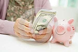 Retired elderly woman counting coins money with piggy bank and worry about monthly expenses and treatment fee payment