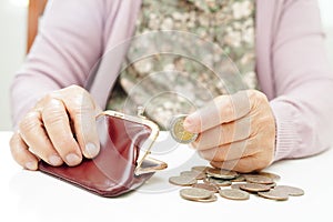 Retired elderly woman counting coins money and worry about monthly expenses and treatment fee payment