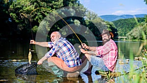 Retired father and mature bearded son. big game fishing. relax on nature. fly fish hobby of men. retirement fishery