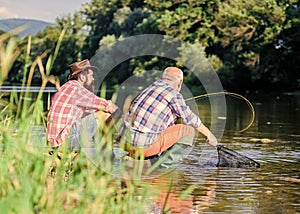 retired father and mature bearded son. big game fishing. relax on nature. Two male friends fishing together. fishermen