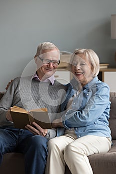 Retired husband and wife spend time reading book at home