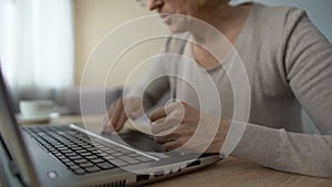 Retired lady studying new computer program, angrily pressing keyboard buttons