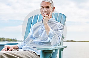 Retired and living life in the slow lane. Portrait of a happy senior man relaxing on a chair outside.