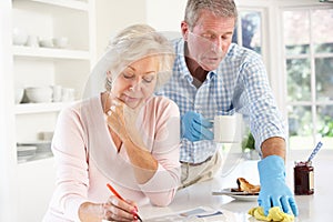 Retired man clearing up after breakfast